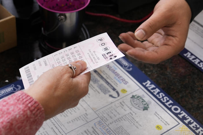 A customer purchases five Powerball tickets at a lottery agent, Tuesday, Oct. 10, 2023, in Haverhill, Mass.