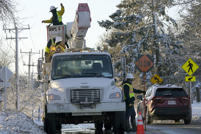 Trucks with cherry pickers help repair damaged power lines, Sunday, Jan. 30, 2022, in Chatham, Mass. An April nor'easter is expected to bring one foot of snow to some places in New England.