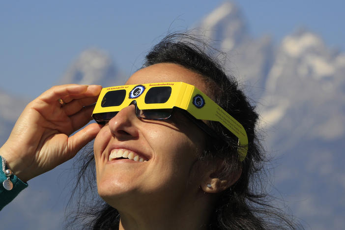 A woman views the solar eclipse in the first phase of a total eclipse in Grand Teton National Park on August 21, 2017 outside Jackson, Wyoming.