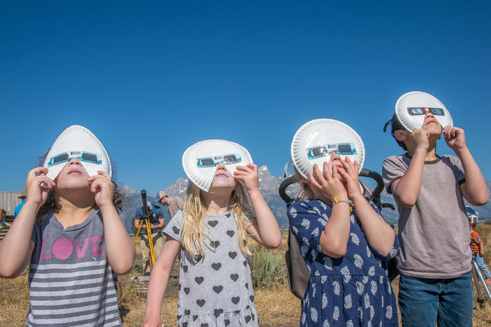 A group of children don eclipse glasses to watch the 2017 solar eclipse at Grand Tetons National Park in Wyoming.