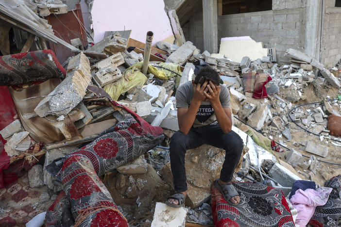A young Palestinian sits on the rubble of a destroyed home following an Israeli military strike on the Rafah refugee camp, in the southern of Gaza Strip, on Oct. 15. Sunday marks six months since the start of the war between Israel and Hamas.