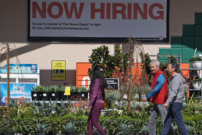 Hiring accelerated in the U.S. in March, adding 303,000 jobs, according to a report from the Bureau of Labor Statistics. The unemployment rate dipped to 3.8%, staying under 4% for more than two full years. People walk past a Home Depot in San Rafael, Calif.