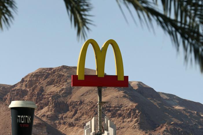 A McDonald's restaurant's iconic "golden arches" logo next to a giant coffee cup of its "Aroma" trademark in the Israeli Dead Sea resort town of Ein Bokek.