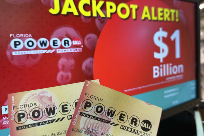 Powerball tickets are shown in front of a screen displaying the estimated jackpot, Wednesday, April 3, 2024, in Surfside, Fla.