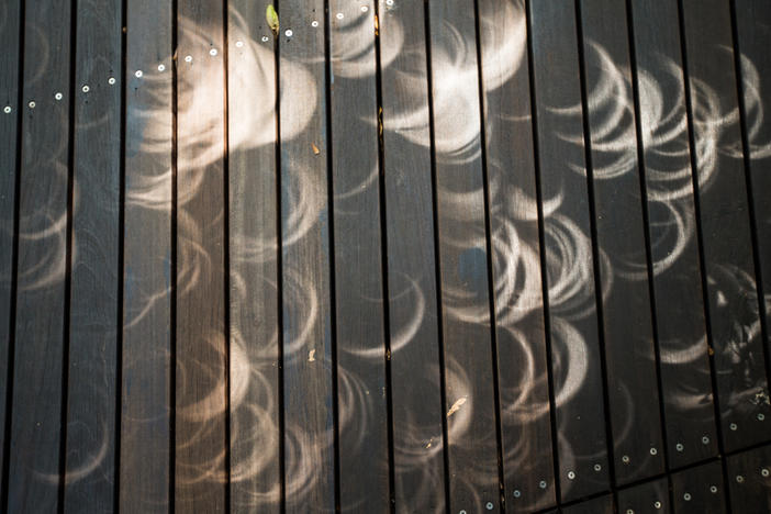 TOPSHOT - Shadows form on the ground as the moon moves in front of the sun in a rare "ring of fire" solar eclipse in Singapore on December 26, 2019.
