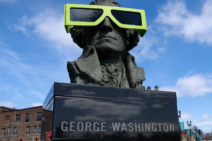 Eclipse glasses are worn by a statue of George Washington on Sunday in Houlton, Maine.