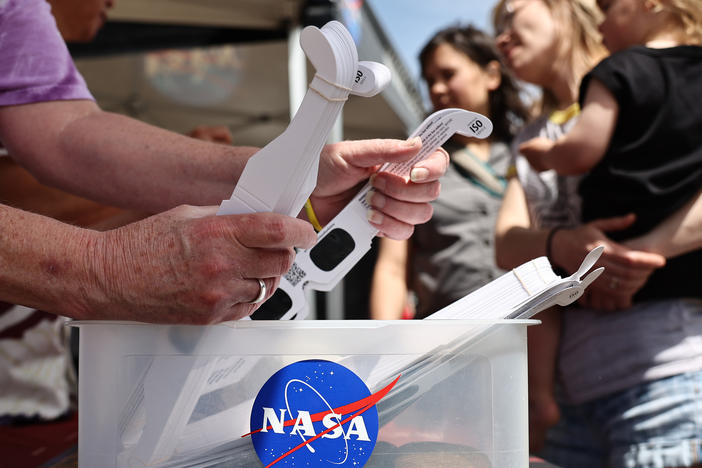 People visit a NASA information booth to grab solar eclipse glasses in Russellville, Arkansas. The space agency has debunked a number of myths about the total solar eclipse — including ideas about food going bad, or unborn babies being harmed.