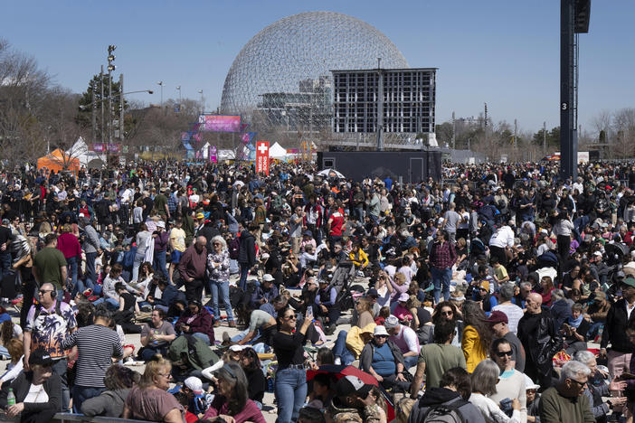 People gather to watch the total solar eclipse at Parc Jean Drapeau, in Montreal, Monday.