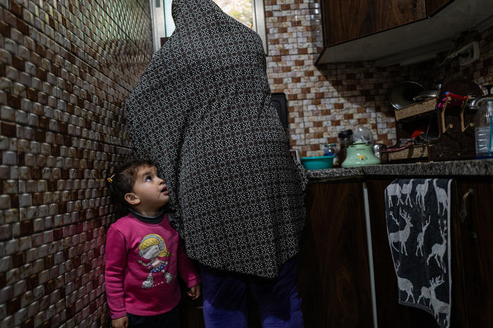 Sally Zeita, 3, stands beside her mother Amani as she prepares a Ramadan dessert at their home in the village Ein 'Arik in the occupied West Bank on March 24.