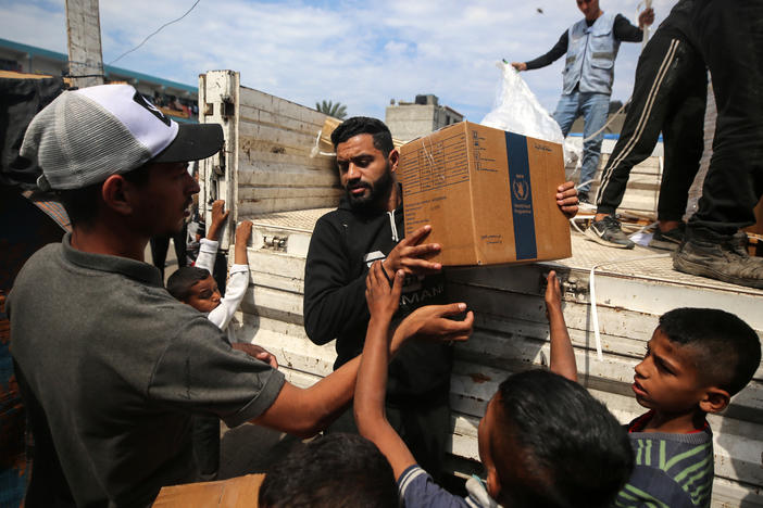 A Palestinian is carrying boxes of aid distributed before the Eid al-Fitr holiday, which marks the end of the Muslim holy fasting month of Ramadan, amid the ongoing conflict between Israel and Hamas, in Deir al-Balah, in the central Gaza Strip, on Monday.