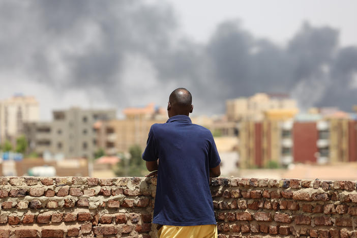 A man looks at the smoke rising next to the Army General Command in Khartoum, Sudan, on April 16, 2023.