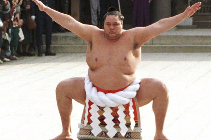 Accompanied by a sword-bearer, grand champion Akebono, right, performs the ring-entrance ritual during the annual New Year's dedication at Meiji Shrine in Tokyo, on Jan. 8, 1997.