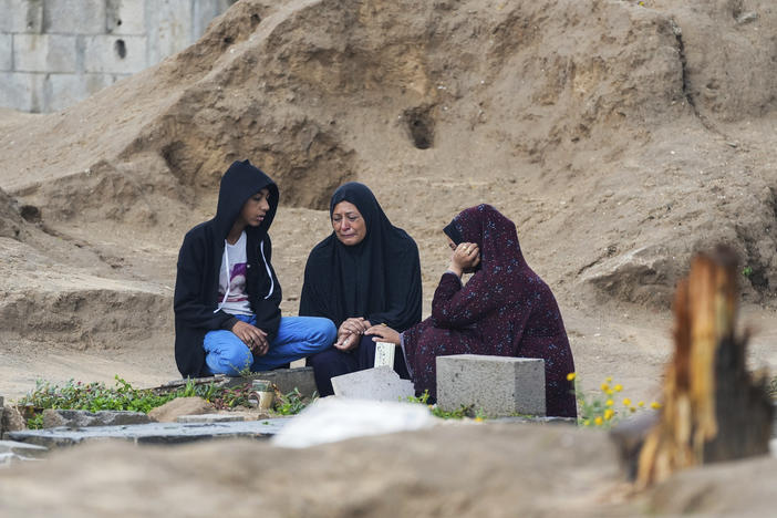Palestinians visit the graves of  relatives killed in the war between Israel and Hamas. The cemetery is in the central Gaza town of Deir al-Balah. Wednesday marked the first day of the Muslim holiday of Eid al-Fitr, but it was a somber day throughout Gaza.