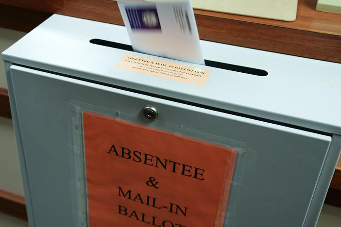 A citizen deposits a ballot into a box at the county clerk's office in Erie, Pa., on Oct. 15, 2020.