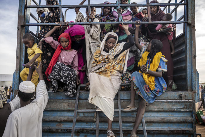 Sudanese refugees who have fled from the war in Sudan get off a truck loaded with families arriving at a transit center for refugees in Renk, South Sudan, on Feb. 13.