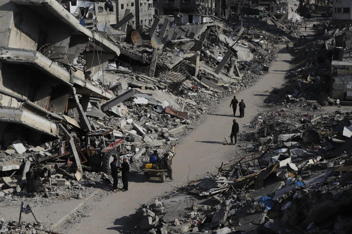 Palestinians walk through the destruction from the Israeli offensive in Jabaliya refugee camp in the Gaza Strip earlier this year.