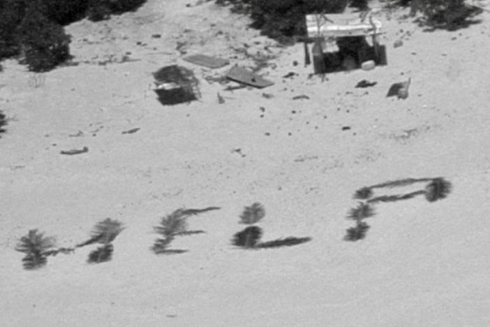 The 'HELP' sign made from palm fronds is shown on the Pikelot atoll.