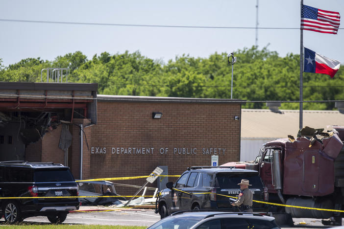 Law enforcement personnel work at the scene after a stolen 18-wheeler crashed into a Texas Department of Public Safety office on US-290 in Brenham, Texas on Friday.