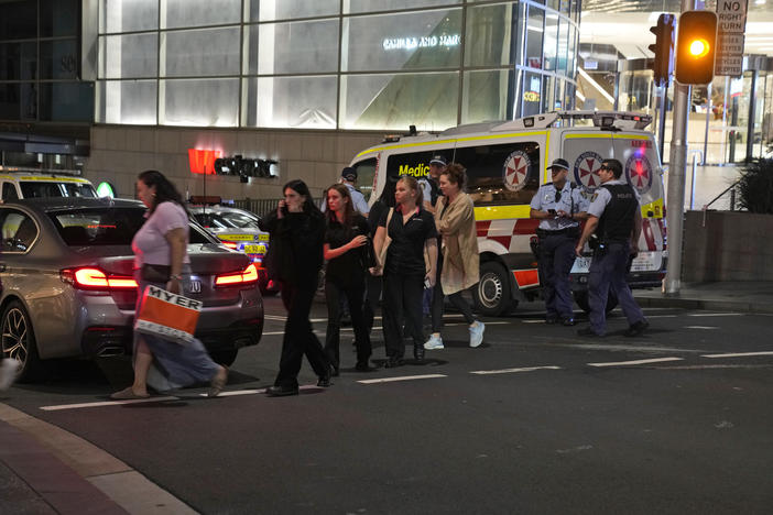 People are led out from the Westfield Shopping Centre where multiple people were stabbed in Sydney on Saturday.