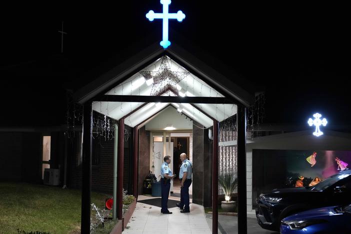 Security officers stand guard outside Orthodox Assyrian church in Sydney, Australia, Monday, April 15, 2024.