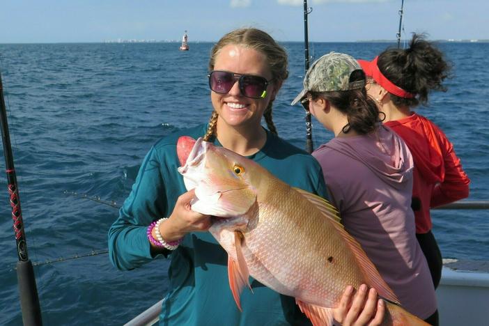 University of Miami Marine Sciences student Lauren Hayes with her catch, a 7 or 8 pound mutton snapper, which was released and returned to its reef habitat more than 100 feet below the surface.