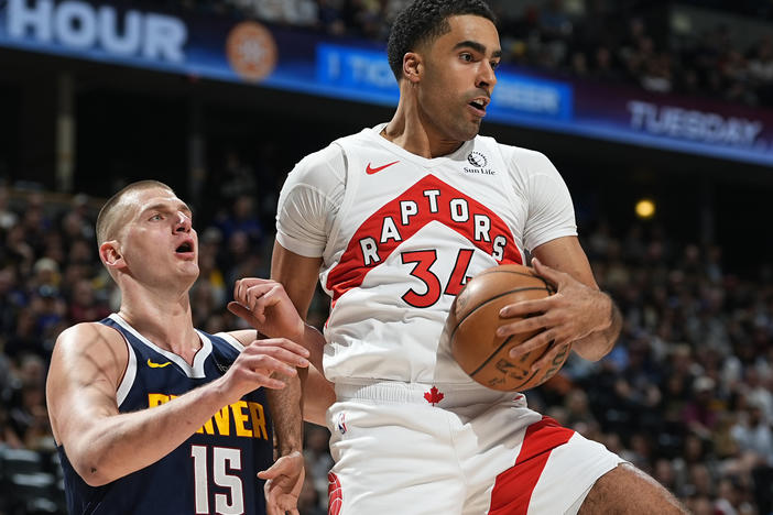 Toronto Raptors center Jontay Porter (right) pulls in a rebound as Denver Nuggets center Nikola Jokic defends in an NBA game on March 11 in Denver. On Wednesday, the NBA banned Porter after a league probe found he disclosed confidential information to sports bettors and bet on games.
