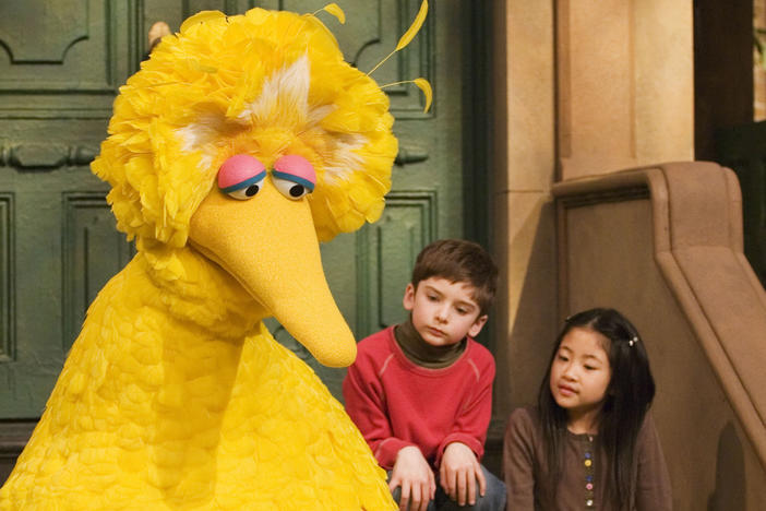 In this 2008 file photo, Big Bird reads to Connor Scott and Tiffany Jiao during a taping of <em>Sesame Street</em> in New York.