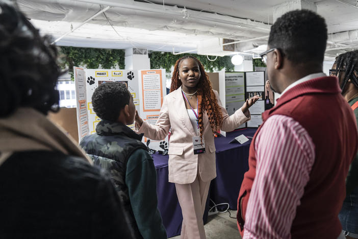 At the National STEM Festival, 12th-grader Treyonna Sullivan talks with visitors about her "Project Poop," created to encourage pet owners in her community to dispose of their pet's waste.
