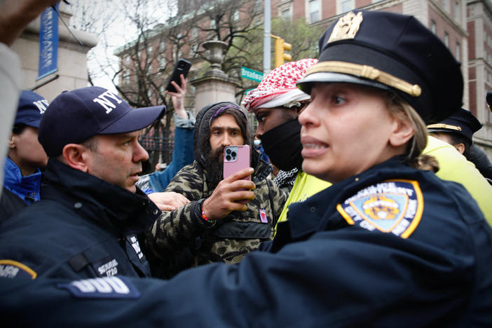 NYPD officers detain a person as pro-Palestinian protesters gather outside of Columbia University in New York City on Thursday. Officers cleared out a pro-Palestinian campus demonstration, a day after university officials testified about anti-Semitism before Congress.