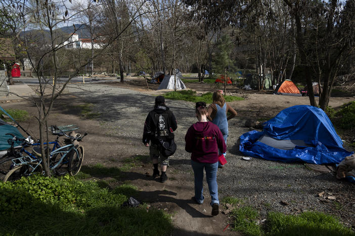 A group of volunteers check on homeless people living in a park in Grants Pass, Ore., on March 21.