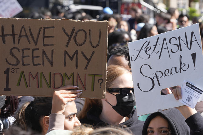 Students carrying signs on April 18, 2024 on the campus of USC protest a canceled commencement speech by its 2024 valedictorian who has publicly supported Palestinians.