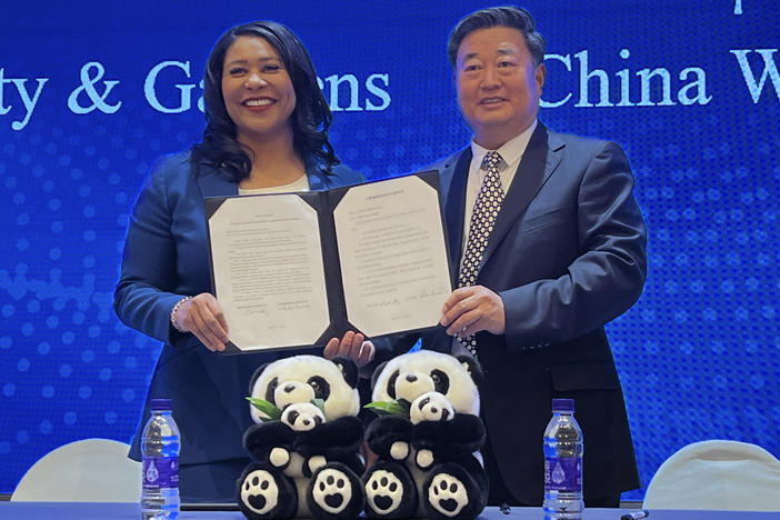 San Francisco Mayor London Breed (left) and Wu Minglu, secretary general of the China Wildlife Conservation Association, hold up an agreement to lease giant pandas for the San Francisco Zoological Society and Gardens during a signing ceremony in Beijing on Friday.