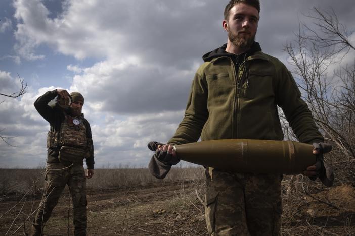 Ukrainian soldiers carry shells to fire at Russian positions on the front line, near the city of Bakhmut, in Ukraine's Donetsk region, on March 25. The outgunned and outnumbered Ukrainian troops have been struggling to halt Russian advances.