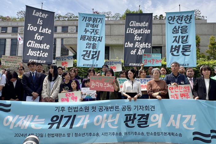 Plaintiffs, lawyers and activists gather outside South Korea's constitutional court in Seoul ahead of a public hearing for a climate lawsuit on Tuesday, April 23, 2024.