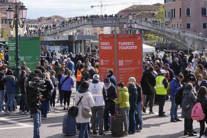 Stewards check tourists' QR code access outside the main train station in Venice, Italy, on Thursday.