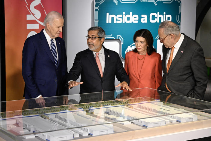 President Biden speaks with Micron CEO Sanjay Mehrotra, New York Gov. Kathy Hochul and Senate Majority Leader Chuck Schumer as they look at a mock-up of a semiconductor facility in Syracuse, N.Y.