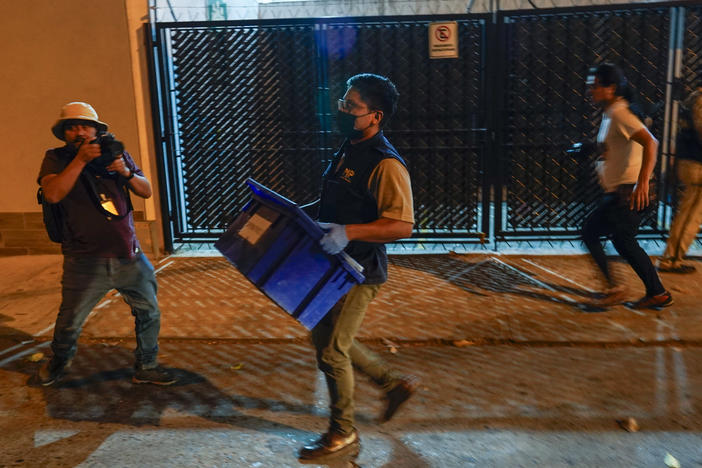 An agent from the attorney general's office carries evidence collected at Save the Children's headquarters during a raid in Guatemala City on Thursday, April 25, 2024.
