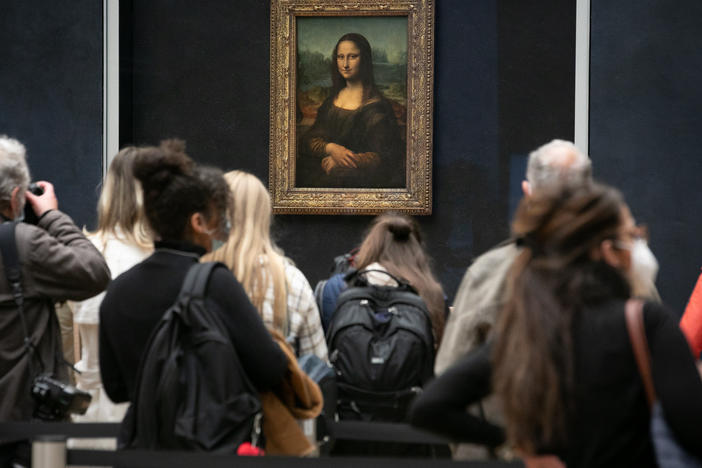Visitors observe the painting the <em>Mona Lisa</em> by Italian artist Leonardo da Vinci on display in a gallery at Louvre on May 19, 2021 in Paris, France.