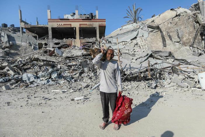 People inspect damage and remove items from their homes following Israeli airstrikes on April 7, in Khan Yunis, Gaza.