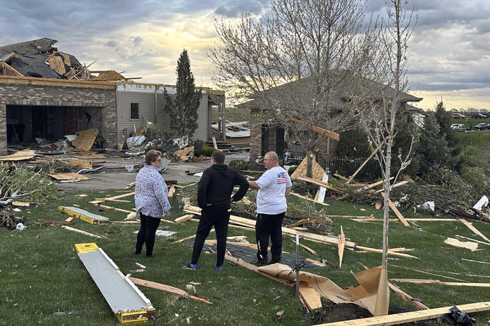 Homeowners in Bennington, Neb., assess the damage after a tornado passed through their neighborhood northwest of Omaha on Friday.