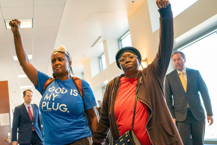 After suspended Aurora Police Officer Nathan Woodyard was found not guilty on charges over his role in the death of Elijah McClain, his mother Sheneen McClain, right, and supporter MiDian Holmes joined hands and raised their fists in protest as they left a courtroom at the Adams County Justice Center, Nov. 6, 2023.