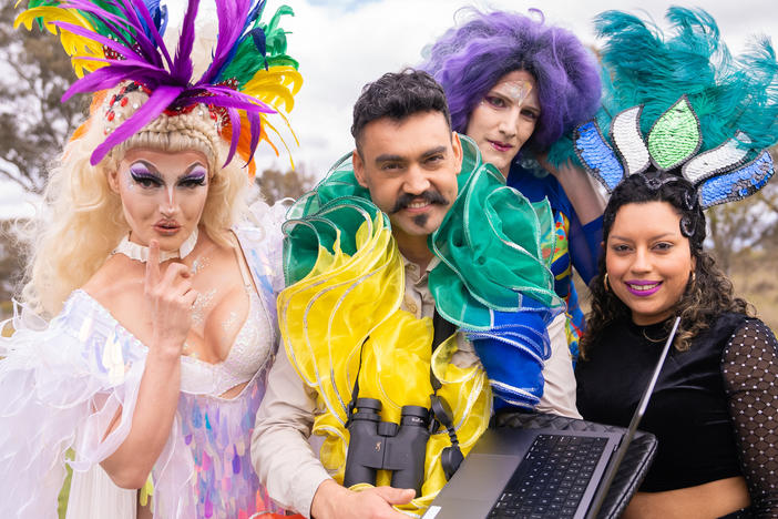 Weliton Menário Costa (center) holds a laptop while surrounded by dancers for his music video, "Kangaroo Time." From left: Faux Née Phish (Caitlin Winter), Holly Hazlewood, and Marina de Andrade.