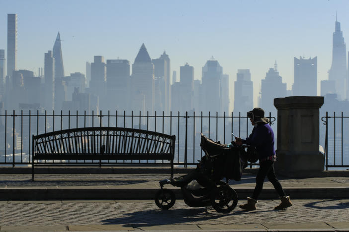 Amazon and Target are among the latest big retailers to stop selling weighted infant sleepwear due to concerns about safety. Here, a woman pushes a stroller as the New York skyline is seen from Weehawken, New Jersey.