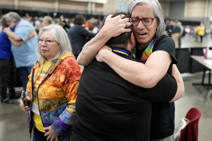 Angie Cox, left, and Joelle Henneman hug after an approval vote at the United Methodist Church General Conference that repealed their church's longstanding ban on LGBTQ clergy and same-sex weddings.