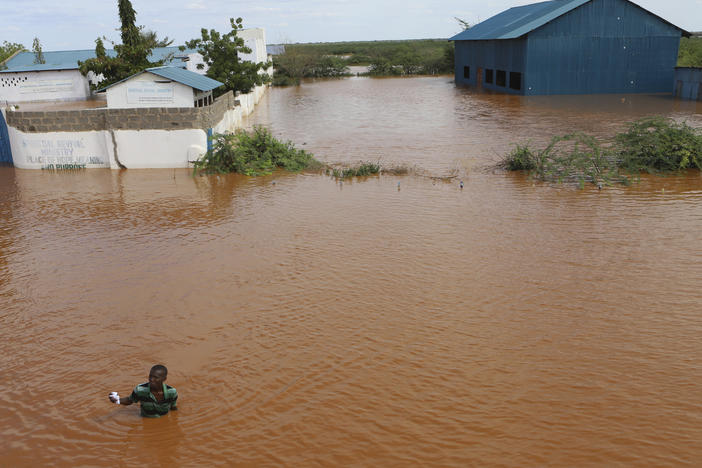 A man swims from a submerged church compound, after the River Tana broke its banks following heavy rains at Mororo, border of Tana River and Garissa counties, northeastern Kenya, April 28. Heavy rains pounding different parts of Kenya have led to dozens of deaths and the displacement of tens of thousands of people, according to the United Nations.