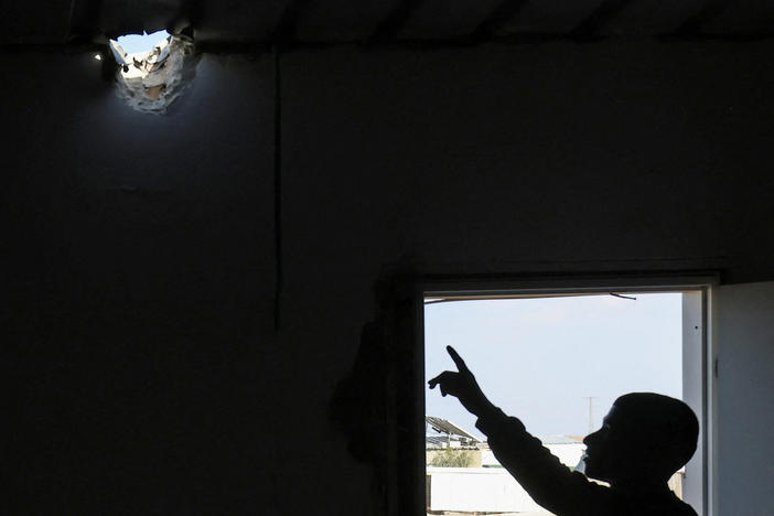 A relative points to a hole in the roof of Mohammed al-Hassouni's family home. It was caused by an Iranian missile fragment that injured his 7-year-old daughter on the night Iran attacked Israel.