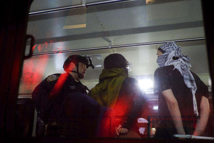 New York Police Department officers load arrested protesters from Columbia University onto a bus, on Tuesday in New York.