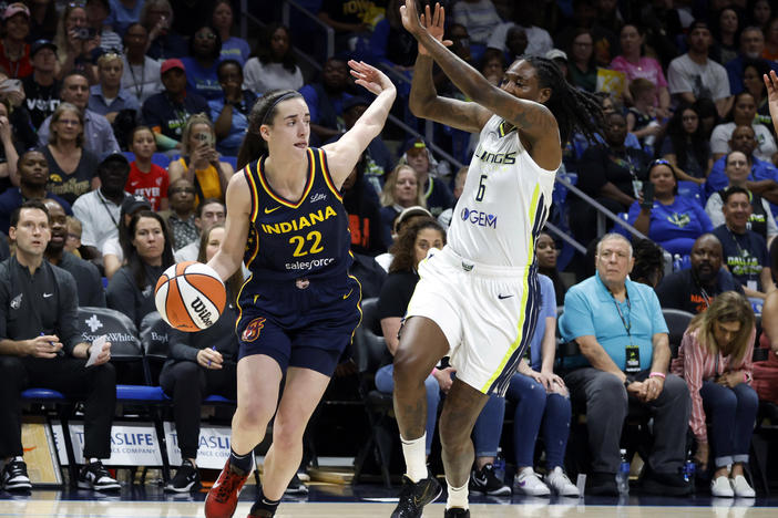 Indiana Fever guard Caitlin Clark (22) drives past Dallas Wings forward Natasha Howard (6) during their WNBA basketball game in Arlington, Texas, on Friday.