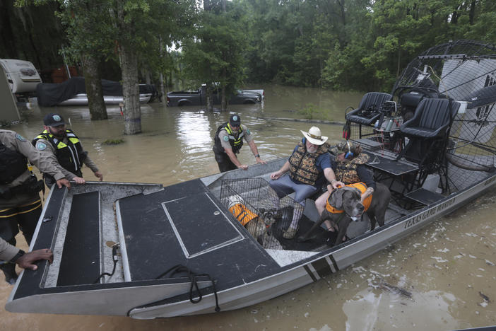 Texas Parks & Wildlife Department game wardens use a boat to rescue residents from floodwaters in Liberty County, Texas, on Saturday.