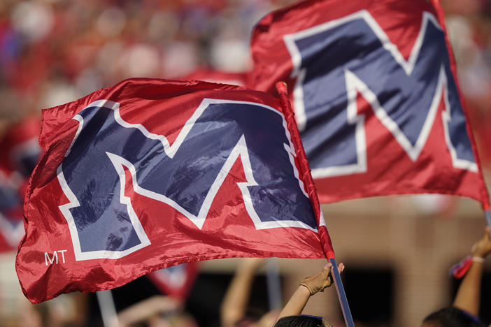 The University of Mississippi's school banner is waved during the pregame activities prior to the start of an NCAA college football game in October 2021. The university's leader denounced actions at a protest last week.
